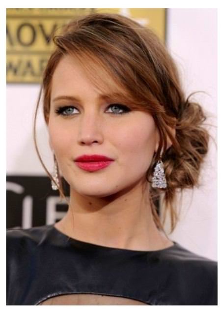 loose bun with long side swept bangs hairstyles for round faces
