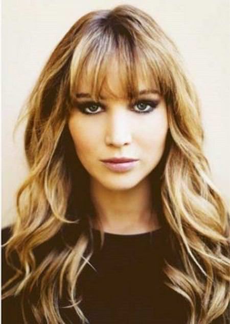 soft golden waves with thick bangs haircuts for curly hair