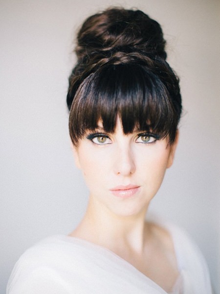 high bun with blunt bangs hairstyles for wedding guests