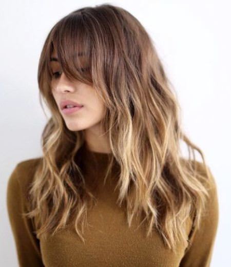 sombre hair with long tigh bangs layered haircut with bangs