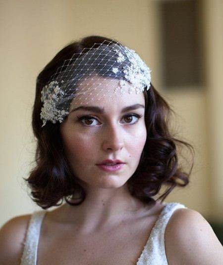 retro curly bob with a bridcage veil wedding curly hairstyles